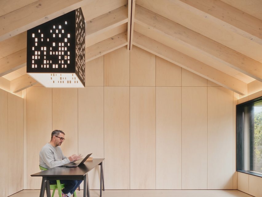 Light chimney and desk in Dark Matter garden studio by Hyper