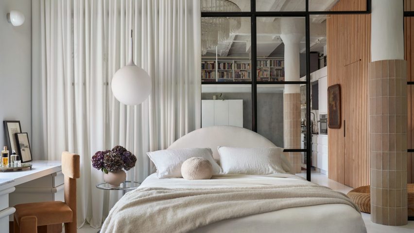 Bed in front of glass partition and white curtain