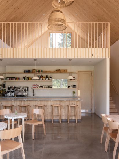 Interior of a timber-clad cafe with a mezzanine floor above the service area