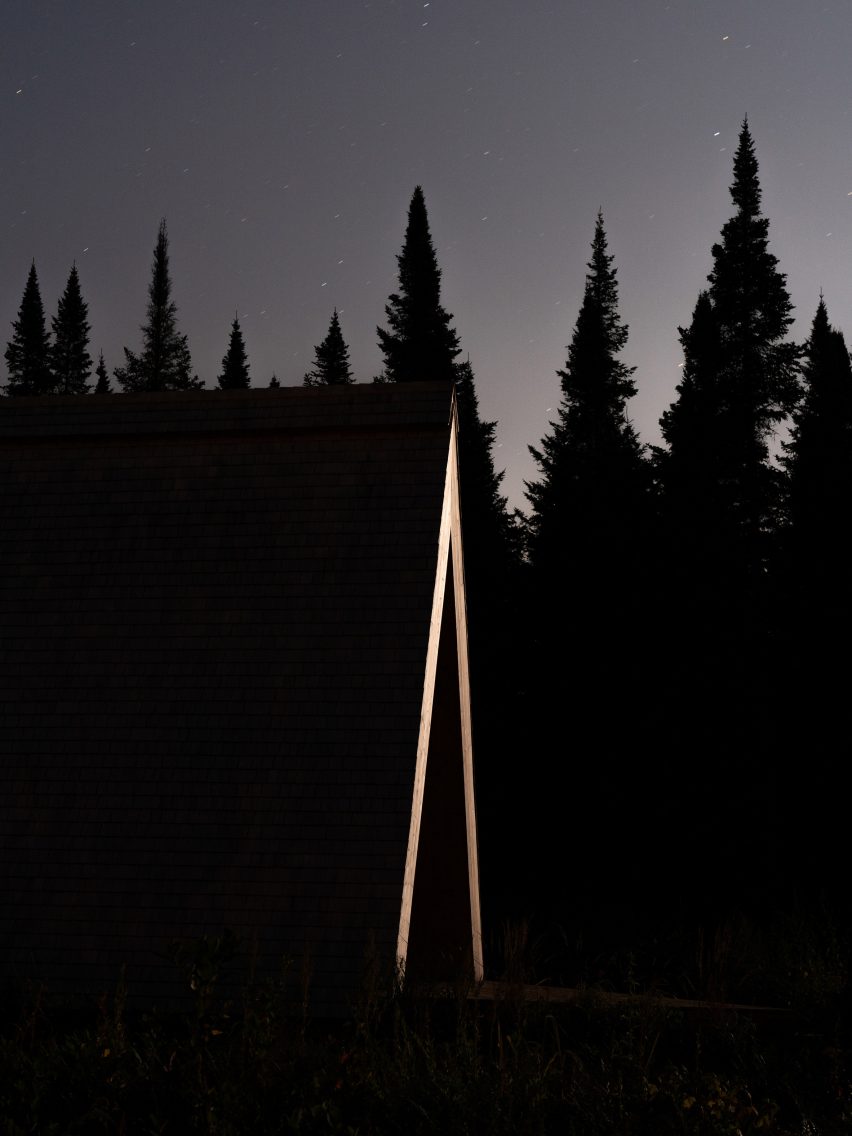 A-frame cabins at night with timber structure highlighted