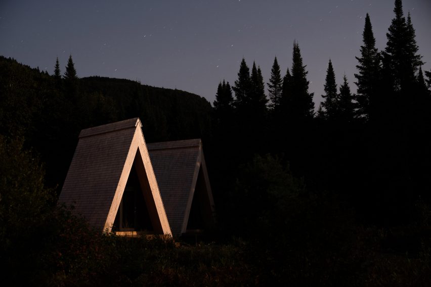 A-frame cabins at night with timber structure highlighted