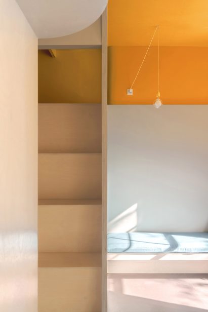 Small wooden steps within compact apartment leading to mezzanine