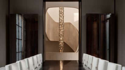 Dining room facing doorway that frames a chandelier