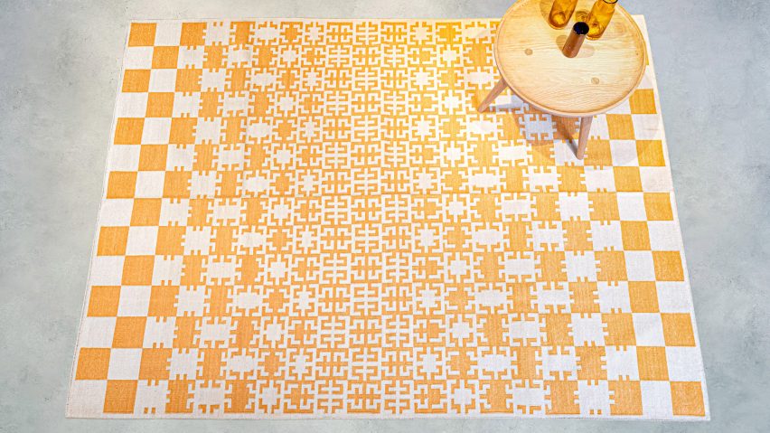 Yellow and off white gridded rug on grey backdrop