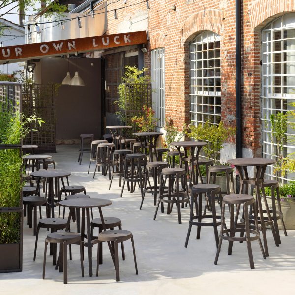 Photograph of tables and stools arranged in outdoor hospitality venue