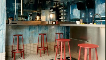 Oyster bar in Paris featuring coral-coloured stools and blue walls