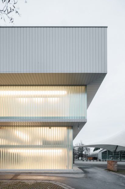 Photograph of detail of building corner, with lights shining through translucent walls