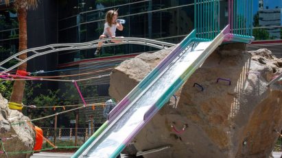 Child next to playground made from rock