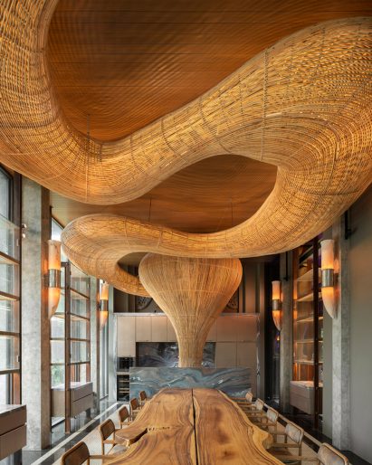 Meandering rattan structure in a dining room by Enter Projects Asia