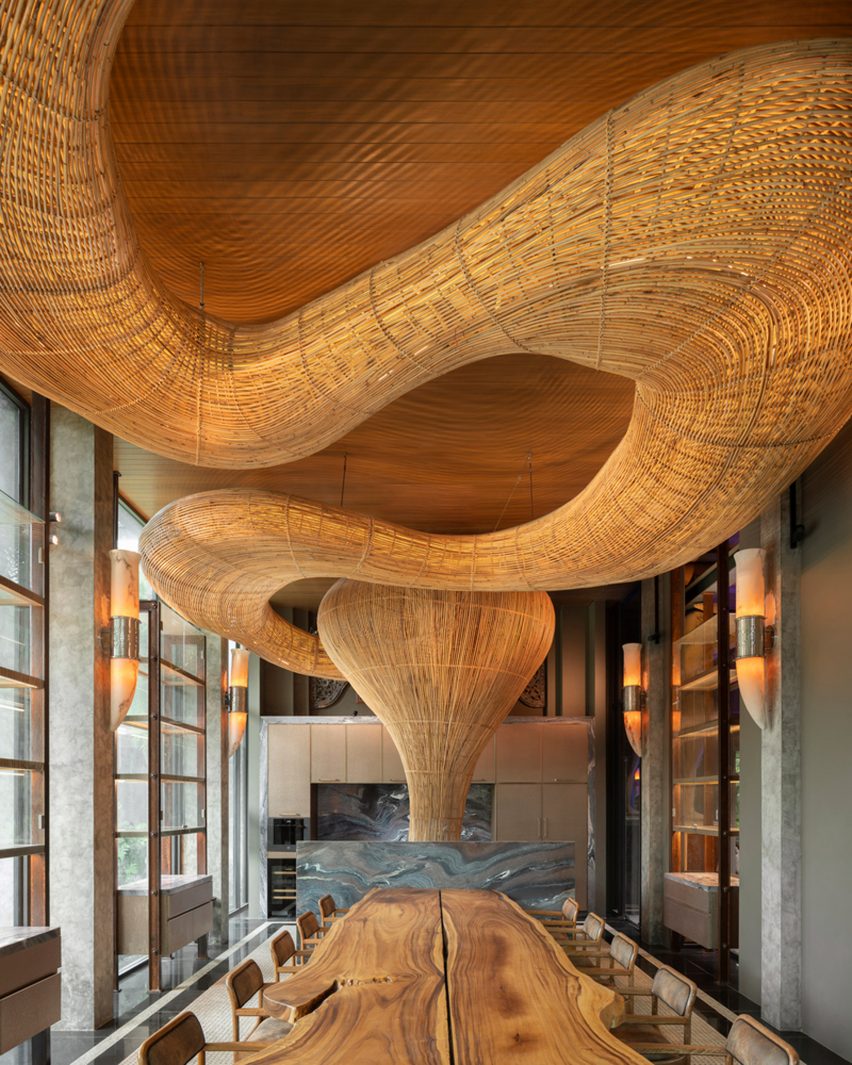 Meandering rattan structure in a dining room by Enter Projects Asia