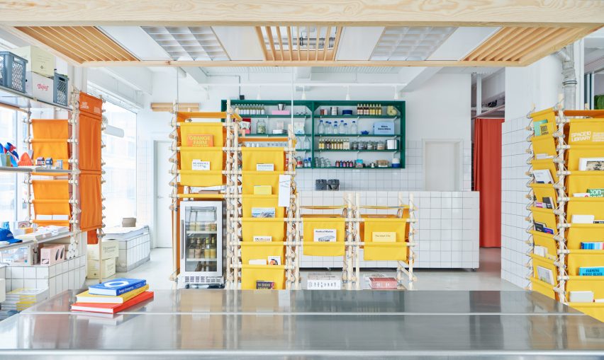 Photo of the central metal table on the ground floor of Space10's headquarters showing the details of a lighting feature made of upcycled metal components in a wooden frame hanging overhead