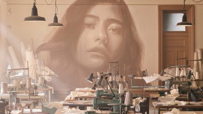 Industrial interior with rows of sewing machines at the Time exhibition by Rone