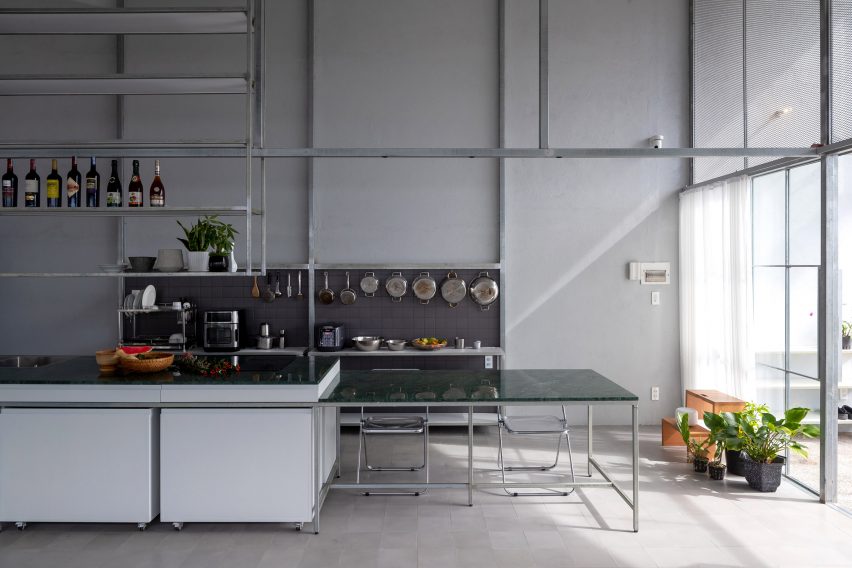 Steel kitchen with kitchen island, green tabletop and shelving display