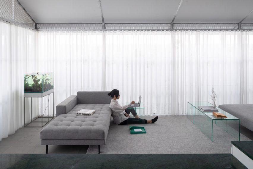 Sofa in a living room with white curtain walls