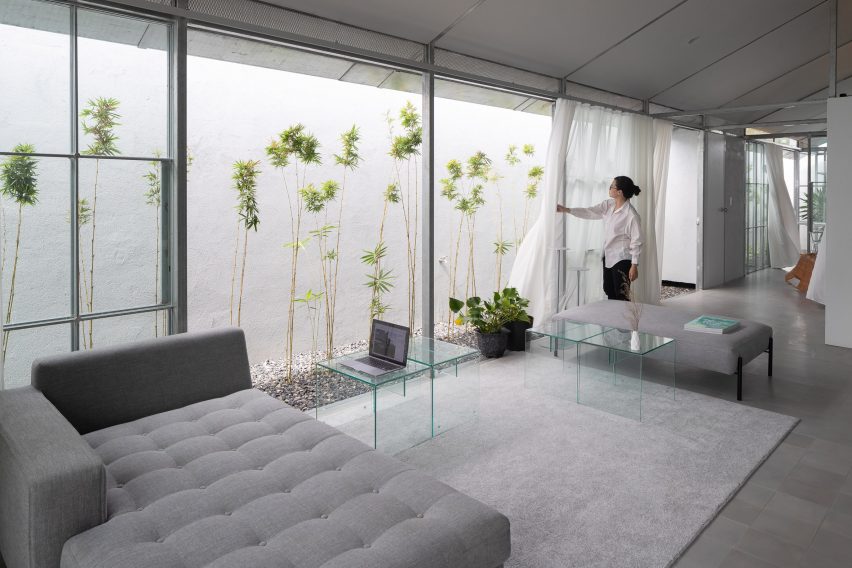 Sofa and tables in a lounge area that opens to a narrow outdoor space