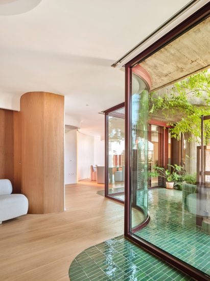 Inside-outside shot of the curvy apartment, with green tiles on the floor