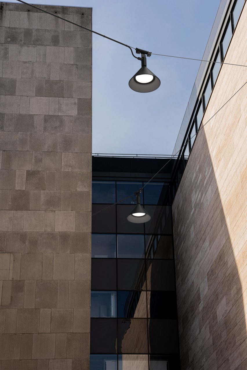 Black lamps suspended along wires between buildings