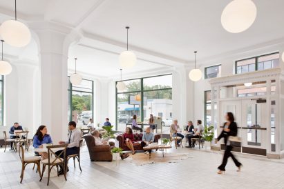Cafe within original vehicle showroom with white walls and floors