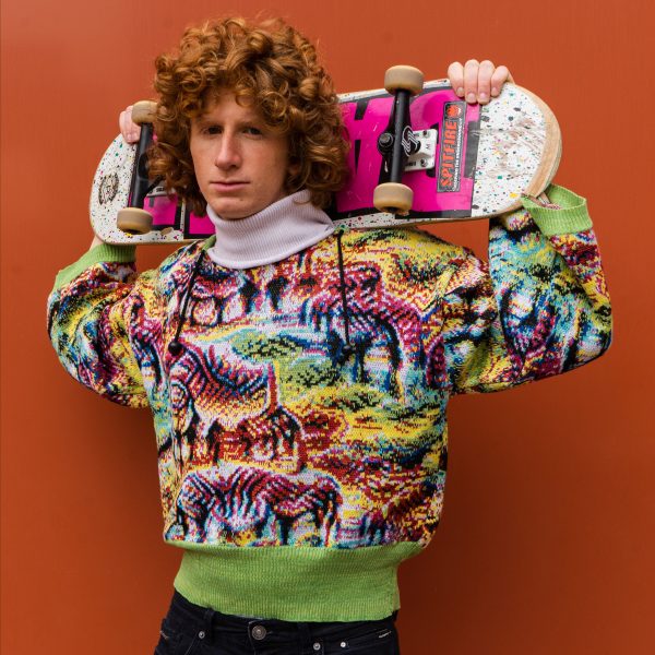 Person wearing Cap_able's garment and holding a skateboard 