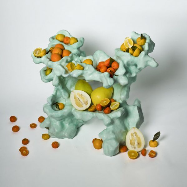 Abstract sculptural piece with citrus fruits balanced upon it