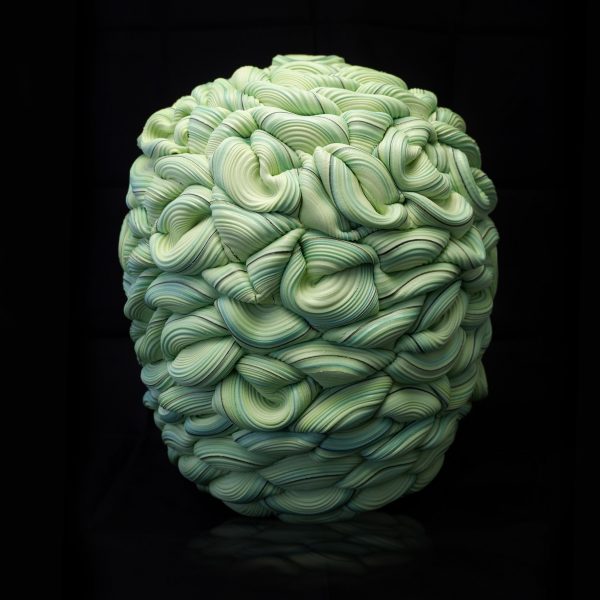 Green sculptural object on black background