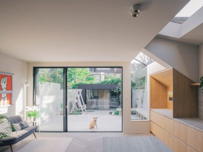 Photograph of a living room with wood and marble materials connected to a courtyard