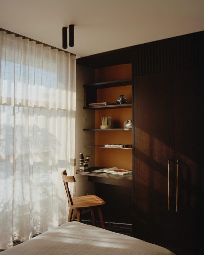 Dark wood desk next to built-in wardrobes in Fisherman's Cottage