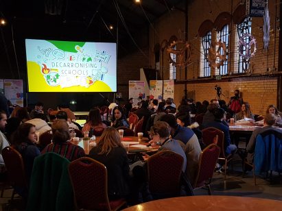 Group of students sitting around tables as part of the Decarbonising Schools workshop