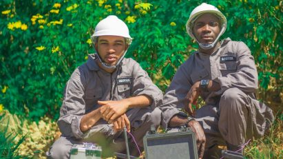 Two designers next to a device designed to monitor pollution in water wells