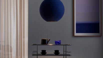 Dark blue round pendant lamp above a trolley