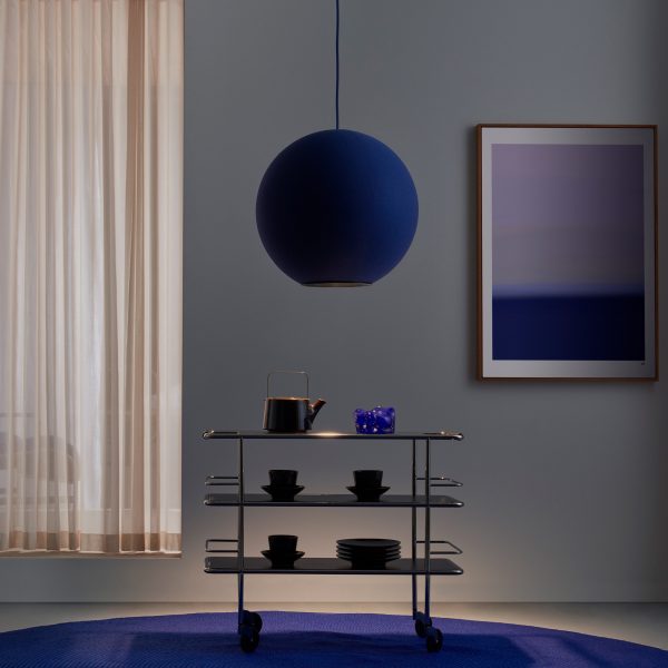 Dark blue round pendant lamp above a trolley