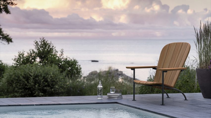 Wooden chair with foot rest by pool in front of sea view