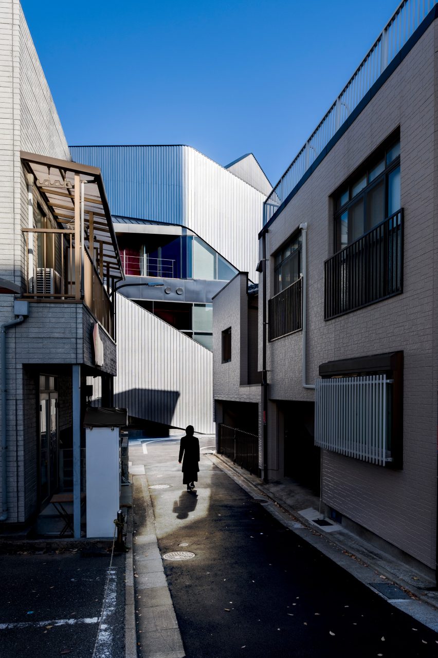 An alleyway in Japan leading to the steel-clad theatre building by Clouds AO