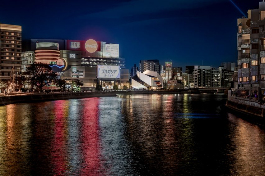 Exterior of a theatre building with sweeping steel panels on a city waterfront by Clouds AO