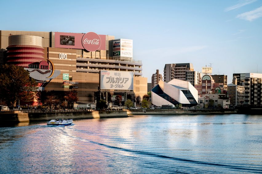 Exterior of a theatre building with sweeping steel panels on a city waterfront by Clouds AO