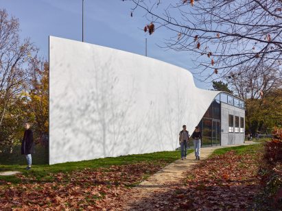 Photo of one side of the Cube building, showing a seamless concrete facade with a twist along its length to form the roof