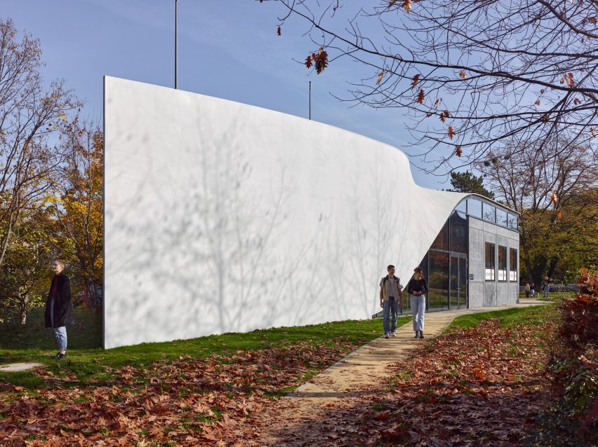 Photo of one side of the Cube building, showing a seamless concrete facade with a twist along its length to form the roof