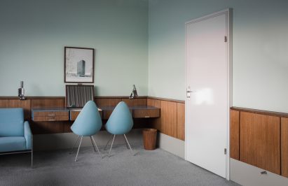 Photograph showing room with white door and light blue walls