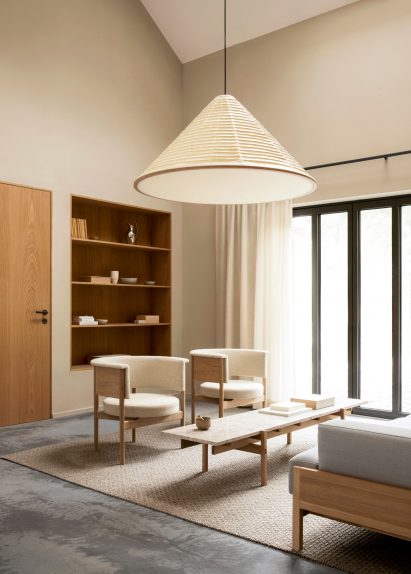Photograph of neutral toned living area with large cone shaped lamp shade