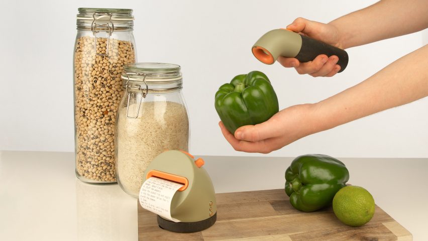 A worktop with glass jars of grains, a wooden chopping board and a person holding a device up to a green bell pepper