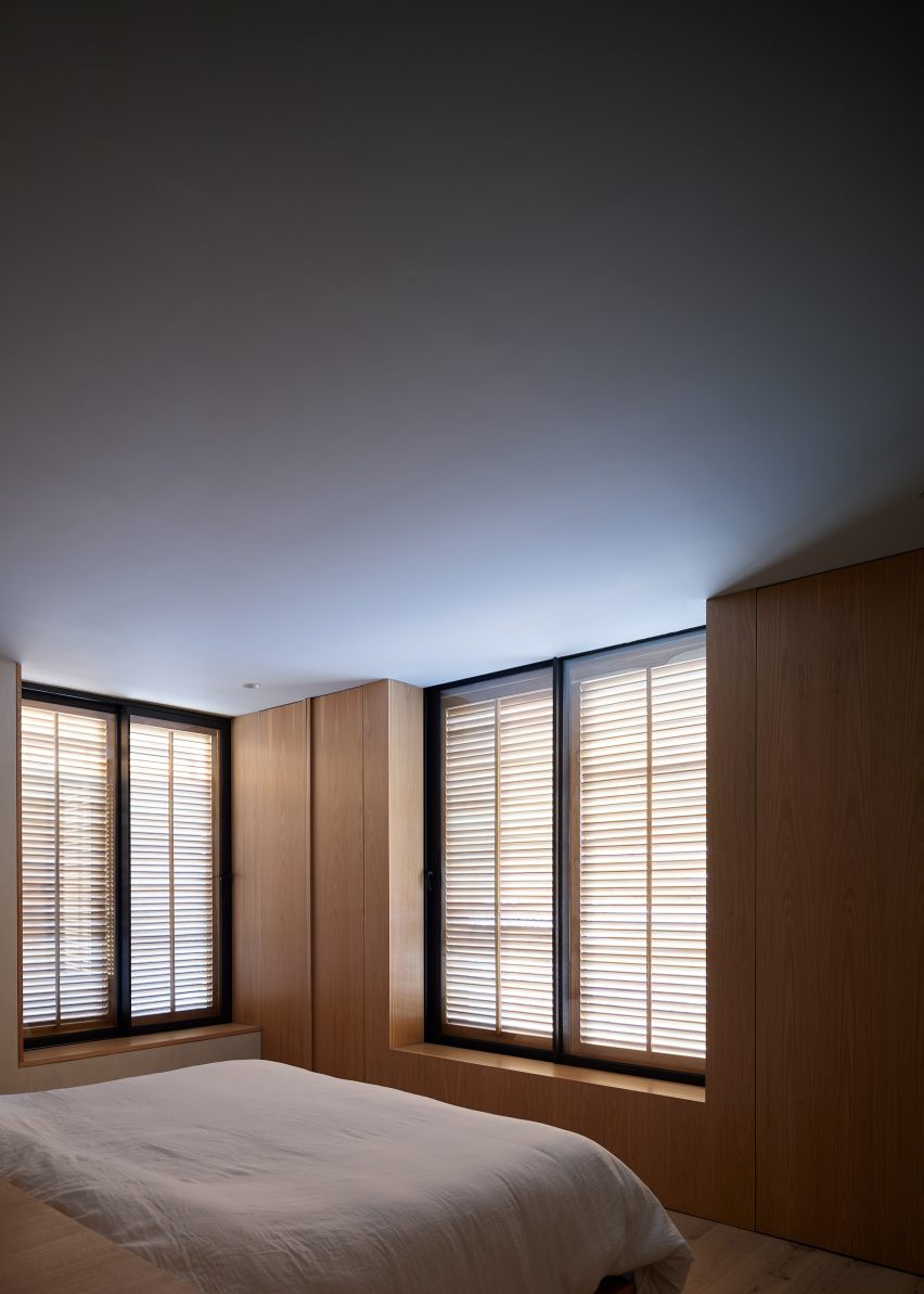 Bedroom with window shutters and and timber wall panelling