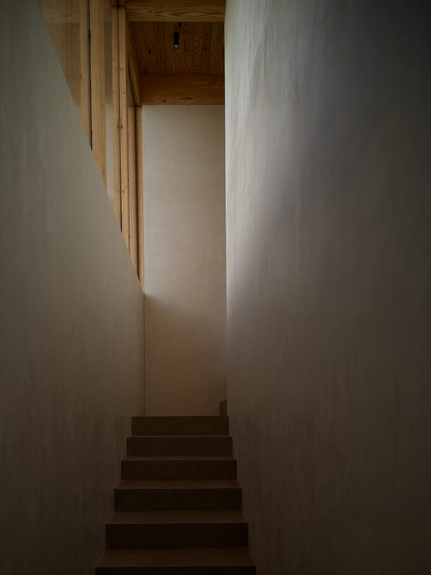 Narrow white staircase with windows in wooden frames