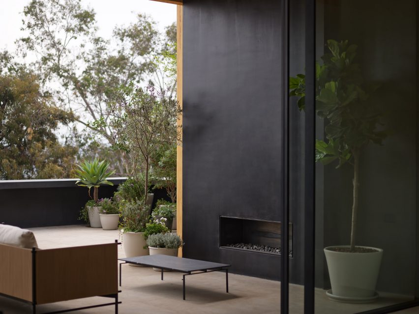 Outdoor terrace with black walls, sofa seating and table