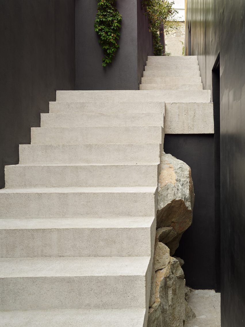 Stone staircase rising over stacked rocks with navy-painted walls