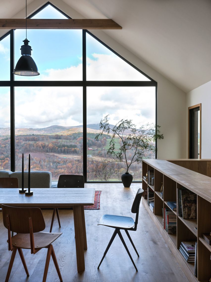 Open-plan dining room with wooden table and chairs and a glazed gable end