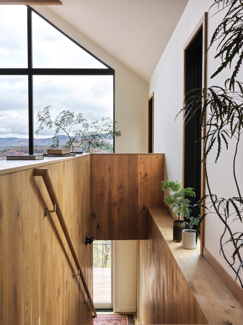 Top of a timber staircase in a pitched-ceiling room with a glazed gable end