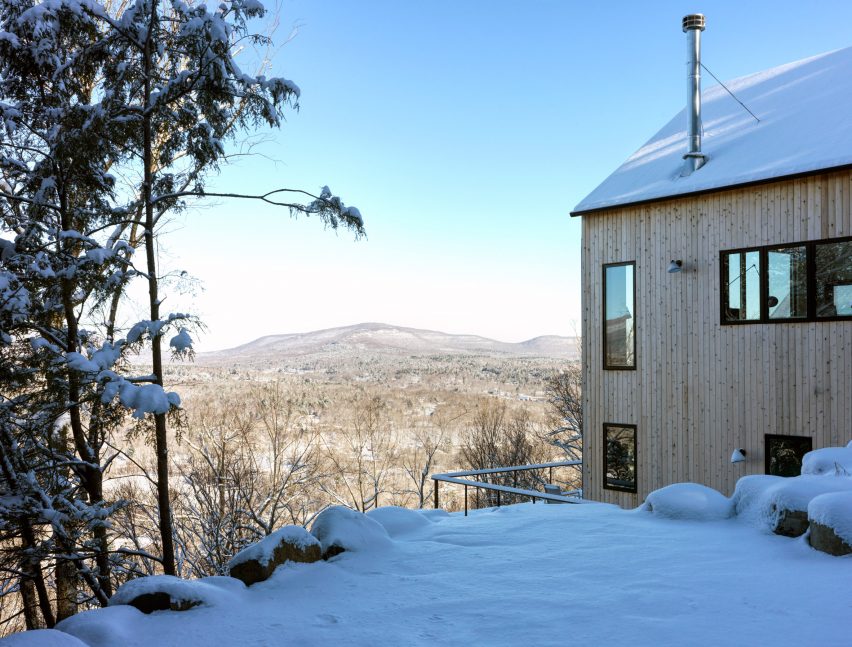 Timber-clad home on a snowy hillside overlooking the landscape
