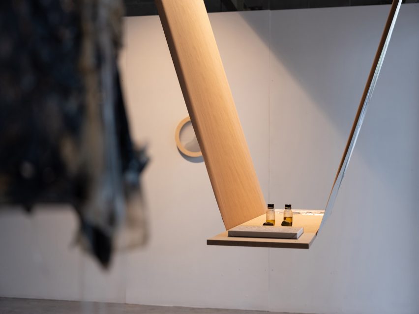 Small tincture bottles standing on plywood shelf hung from ceiling