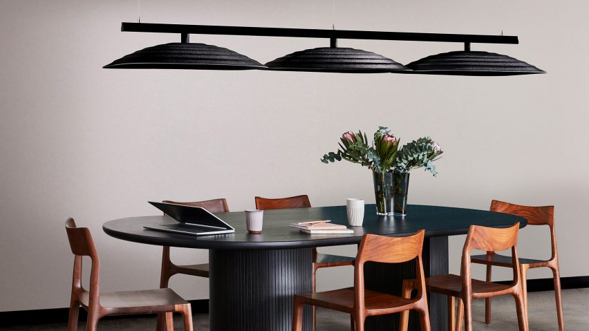 Photo of black Fuji acoustic ceiling tiles suspended above a table
