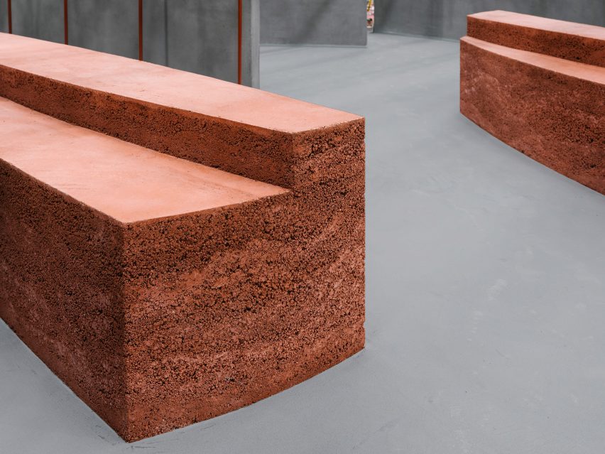 Shop interior with grey flooring and rammed-earth display island